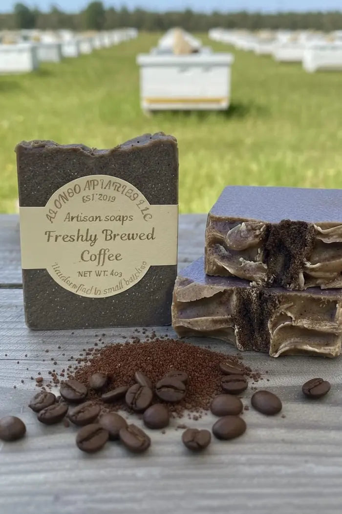 Artisan soap bar labeled 'Freshly Brewed Coffee' with coffee beans on a wooden surface.