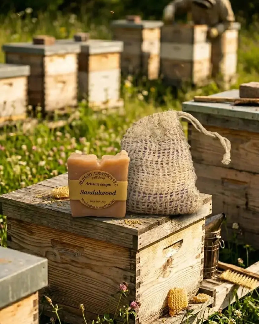 Bar of soap with a label on a wooden beehive box in a beekeeping setting.